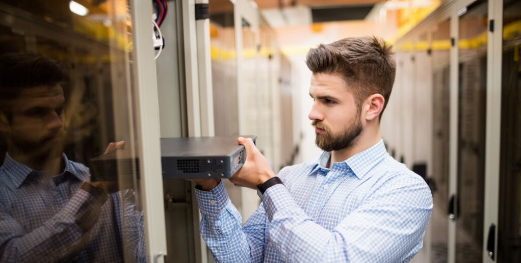 Technician removing server from rack mounted server